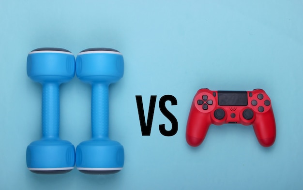 Sport or entertainment. Gamepad and dumbbell on a blue