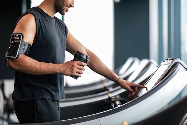 Sport Equipment Crop Of Black Male Selecting Mode On Treadmill Before Jogging