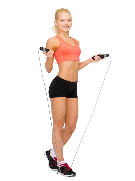 sport, excercise and healthcare - smiling sporty woman with skipping rope