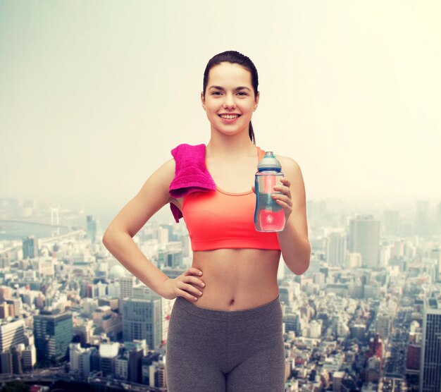 sport, exercise and healthcare - sporty woman with pink towel and water bottle