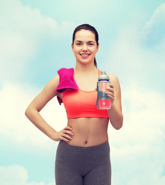 sport, exercise and healthcare - sporty woman with pink towel and water bottle