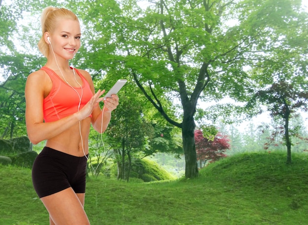 sport, fitness, technology, internet and healthcare - smiling sporty woman with smartphone and earphones