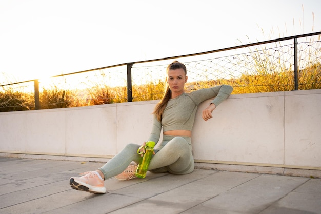 Sport and Fitness Young Adult Caucasian Woman Sitting concert floor Resting after morning Workout