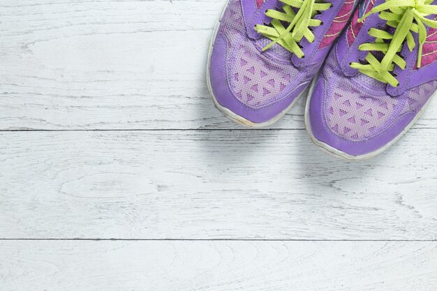 Sport flat lay shoes on white wooden background with copyspace.