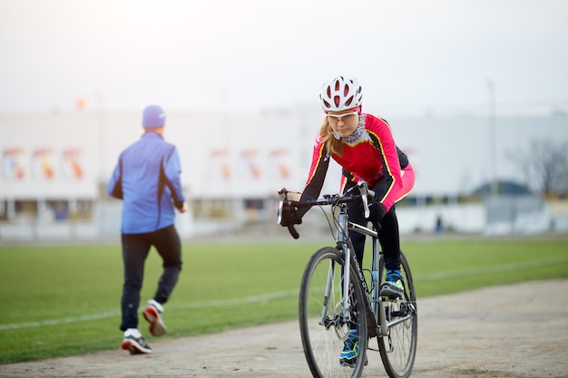 Sport girl cycling in the autumn overcast weather day