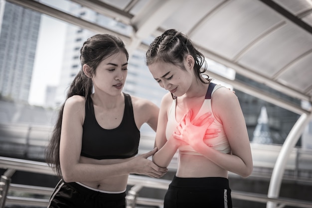 Sport girl, women is clutching her chest, acute pain possible heart attack