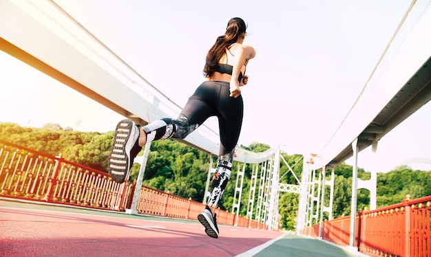 Sport and health lifestyle. Back view shot of Running young woman in sport clothes outdoors