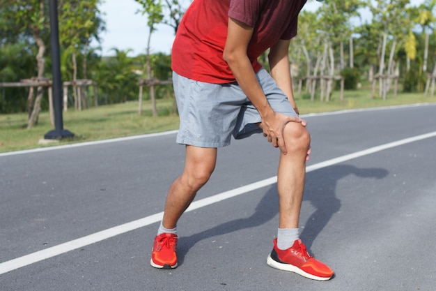 Sport man suffering with pain on sports running knee injury after running