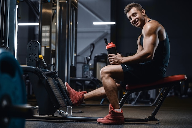 Sport muscular fitness man drinking water after workout