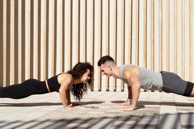 Sport people exercising planking together on street