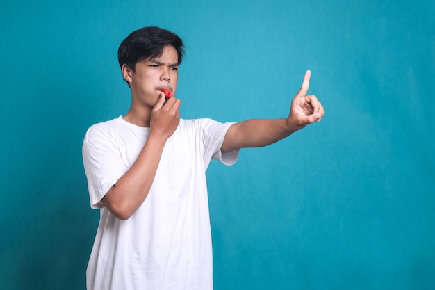 Sport referee blowing whistle and pointing with finger