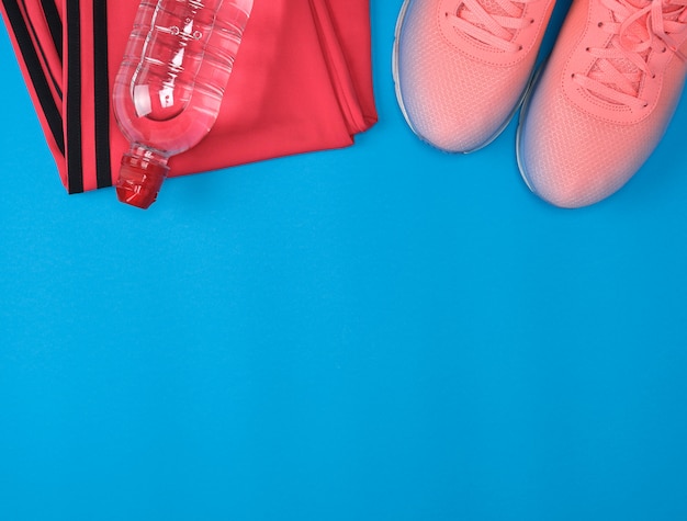 Sport textile shoes and other items for fitness on a blue background