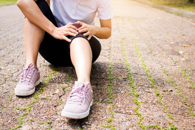 Sport woman has knee pain or leg injury after work out in park