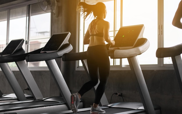 Sport woman running on treadmills doing cardio training Cross fit body and muscular in the gym