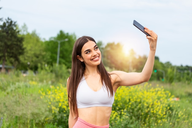 Sport woman smile at camera self picture at street, young girl picture herself exercising fitness