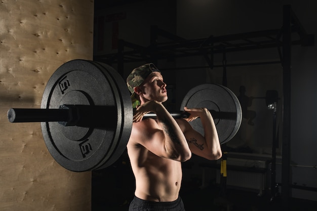 Sport, workout. Closeup portrait of a muscular man workout with barbell at gym.