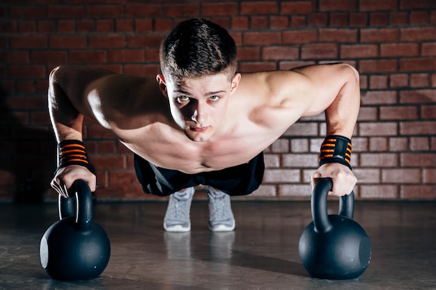 Sport. Young athletic man doing push-ups. Muscular and strong guy exercising.