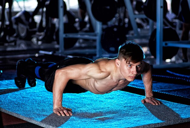 Sport Young athletic man doing pushups Muscular and strong guy exercising