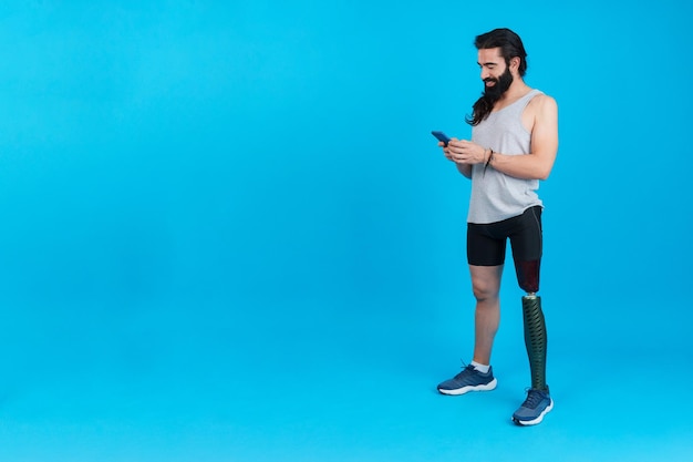 Sportive man with a leg prosthesis using a mobile