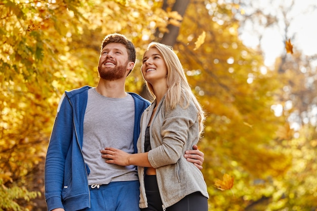 Sportive married couple have leisure adventure time in the forest, stand in contemplation