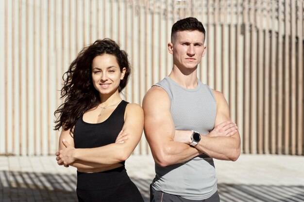 Sportive people showing fit bodies and posing on city street