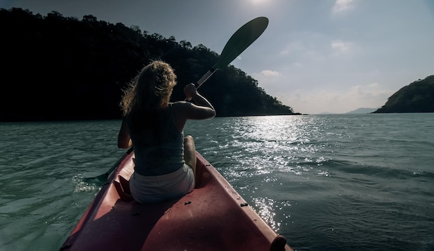 Sportive woman rows pink plastic canoe along sea water