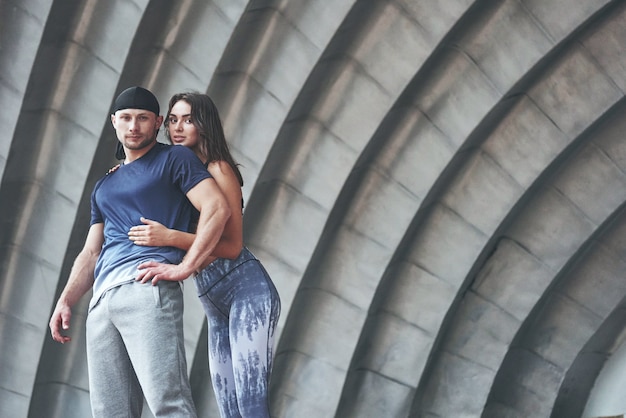 A sports couple resting after a workout is a sexy woman and a man.