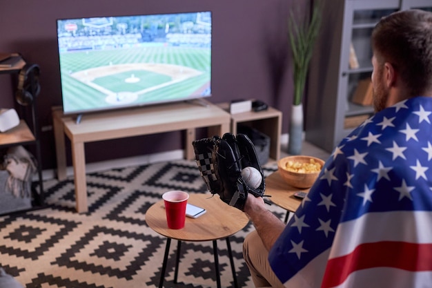 Sports fan watching baseball match at home on TV