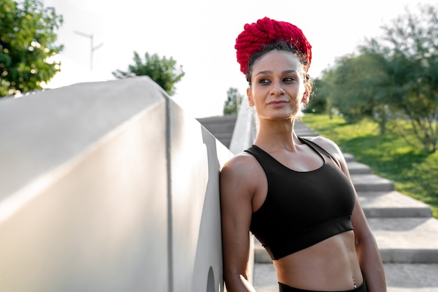 Sports girl, girl in sportswear, outdoor workout, Woman in sports tops, Black clothing for sports, girl with dreadlocks, girl near concrete railing