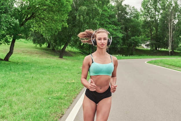 Sports girl jogging in the park The concept of a healthy lifestyle Sports Equipment Fitness style advertisement