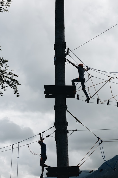 Sports male silhouette in a rope Park in a beautiful forest