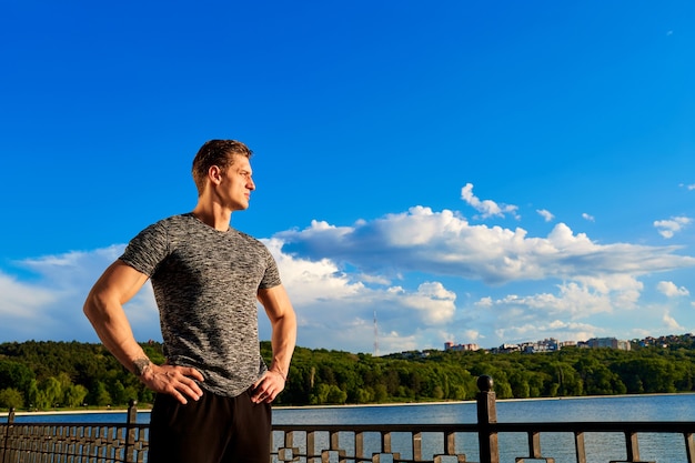 Sports man body figure with the blue sky in the background confident look