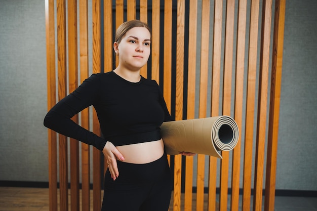 Sports during pregnancy Cheerful young pregnant woman doing sports on a sports mat Healthy lifestyle during pregnancy