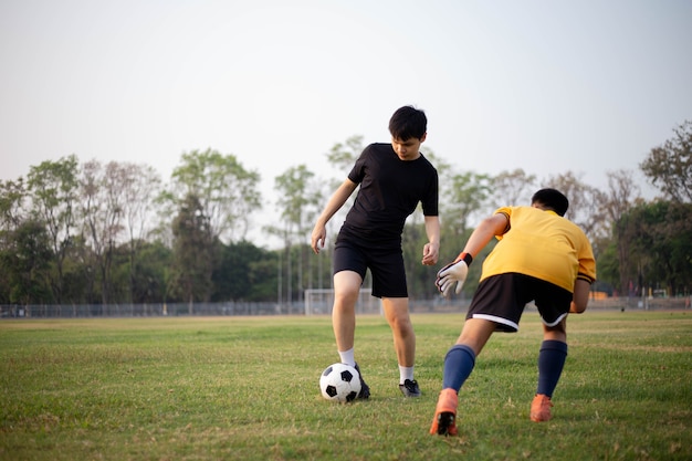 Sports and recreation concept two male soccer players attending regular practice sessions and memorizing attack and defense patterns.