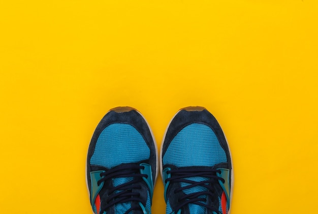 Sports shoes (sneakers) on a yellow background. Healthy lifestyle, fitness training. Top view