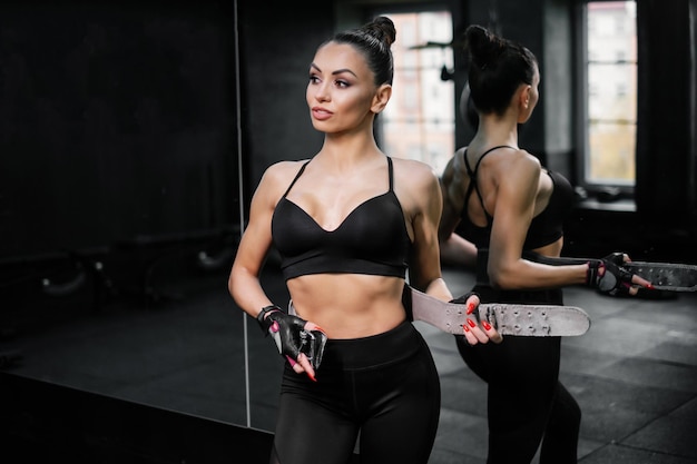 Sports woman putting on an athletic belt Concept of a healthy lifestyle and a slim body