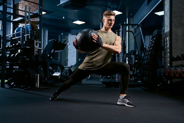 Sportsman doing lunges using ball.