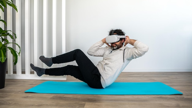 Sportsman enjoying virtual reality glasses to practicing exercise at living room Man exercising while using vr headset for sport Smart fitness and innovation concept