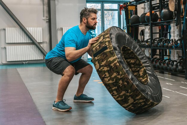 Sportsman exercising with a training wheel and looking determined