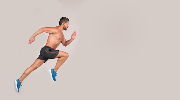 Sportsman man runner run to success or jump high on grey background, copy space, sport.