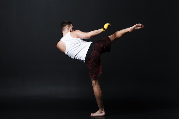 Sportsman muay thai man boxer stance at black background