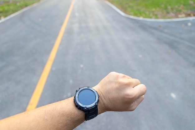 Sportsman wearing digital smart watch in hand