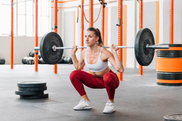 Sportswoman doing barbell back squat