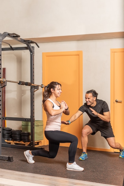 Sportswoman doing squats without weighting exercise in gym. Concept of gym.