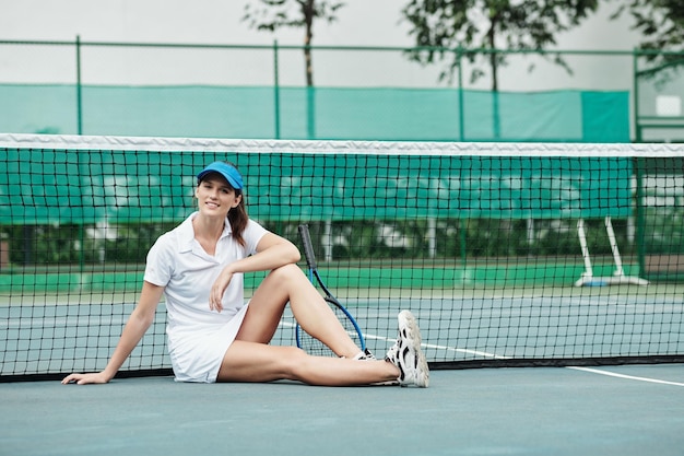 Sportswoman Sitting on Outdoor Tennis court