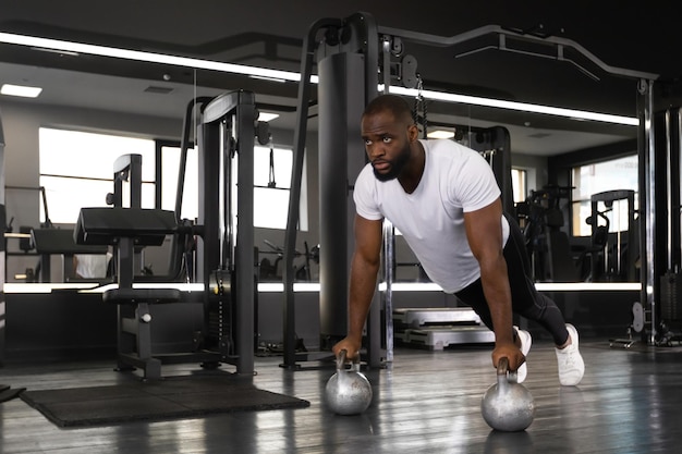 Sporty african man doing pushup in a gym