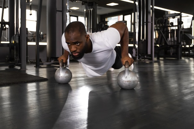 Sporty african man doing pushup in a gym