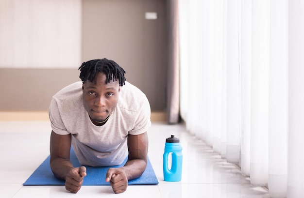 Sporty black man doing yoga plank at home Workout and exercising