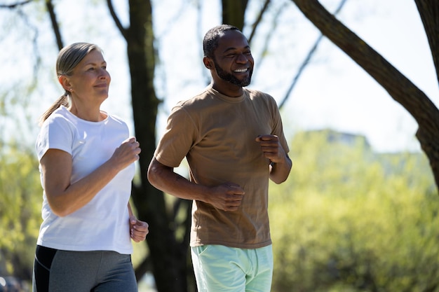 Sporty couple Happy couple jogging together in the park and looking exciting