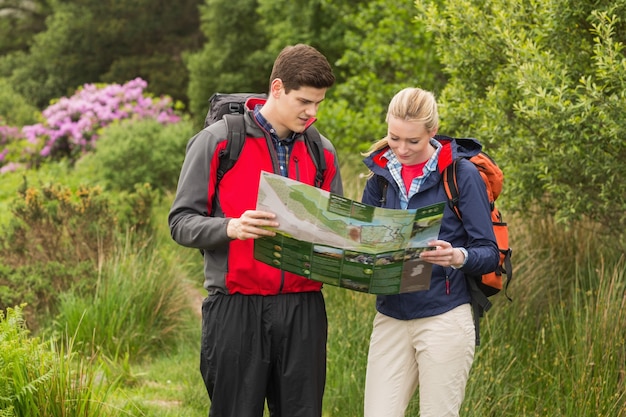 Sporty couple on hike looking at map